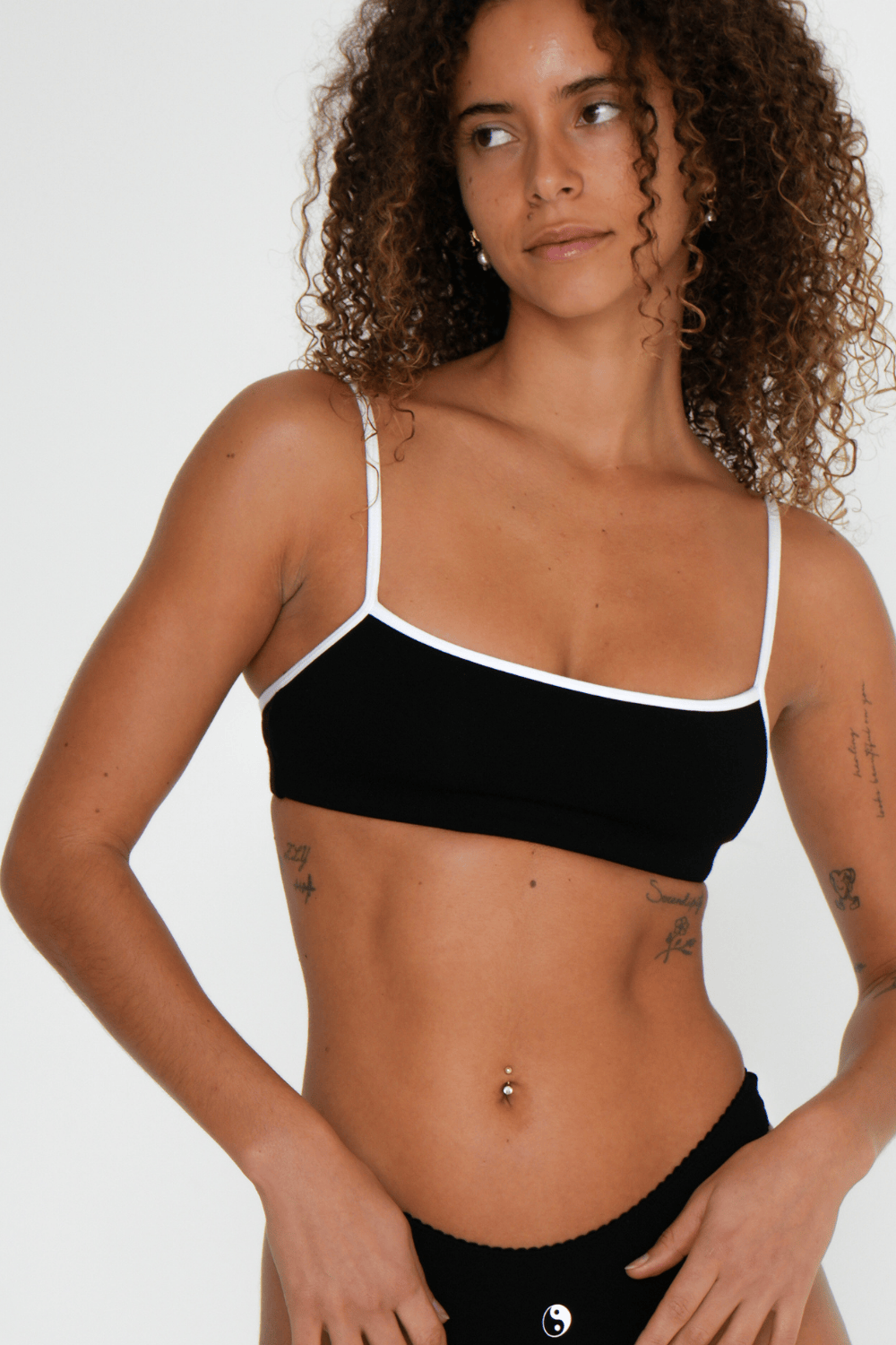 Women’s natural fibre bamboo bralette in black with white contrast strap, breathable, wireless and soft for sensitive skin on model with white background